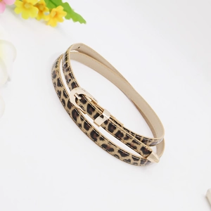 Detail of slim leopard print belt for women with golden metal buckle on white background