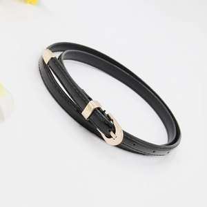 Detail shot of a black thin leather belt with a gold buckle and floral decor