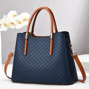 Blue woven minimalist tote bag with brown leather handles and golden metal buckles