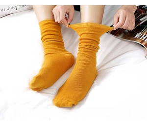 Close-up of bright yellow ribbed knit slouch socks showing elastic texture and retro style