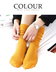 Macro view of bright yellow slouch socks featuring a ribbed knit texture and soft folds