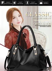 Detail of black litchi pattern PU leather handbag with elegant gold hardware and strap