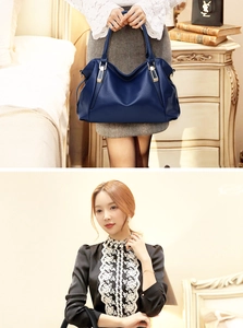 Detail of navy blue pebble leather tote bag featuring gold hardware and pleated side design