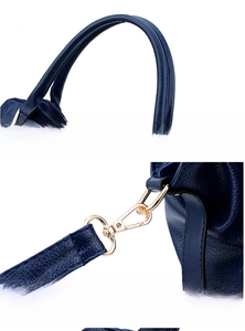 Detail of dark blue lychee leather handbag with ergonomic handle and gold metal buckles
