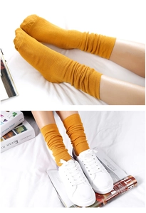 Detail of ginger yellow slouch socks with ribbed texture and loose fold styling