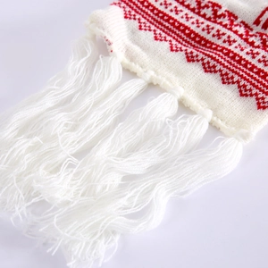 Detailed close-up of knitted Christmas scarf showing red fabric and long white tassels