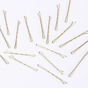 Flat lay view of multiple golden wavy metal hairpins on a clean white background