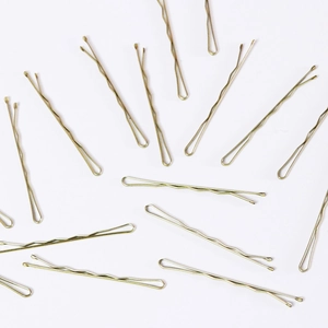 Close-up of golden wavy metal bobby pins scattered on a clean white background