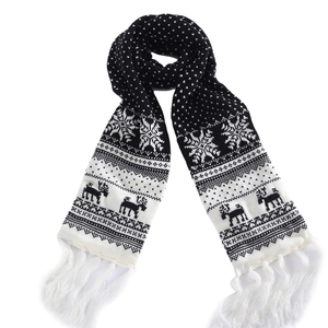 Close-up of black and white Christmas knit scarf with reindeer patterns and tassel detail