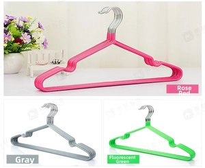 Detail of non-slip clothes hangers with shoulder grooves in rose red, grey and green colors