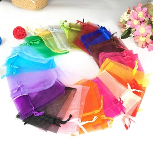 Overhead view of various colorful organza drawstring gift bags arranged in a circle