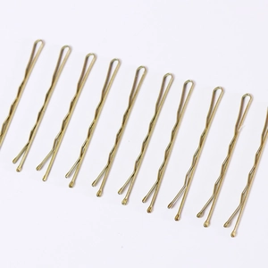 Set of 10 gold metal wave hairpins for women in a diagonal arrangement on white backdrop