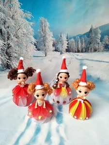 Detail shot of four Christmas doll ornaments with red hats and colorful tulle skirts
