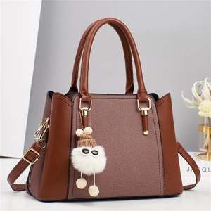 Sac à main en cuir marron et tissu tressé avec bandoulière et pompon en peluche