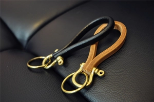 Detailed close-up of premium black and brown leather keychains with vintage brass hardware