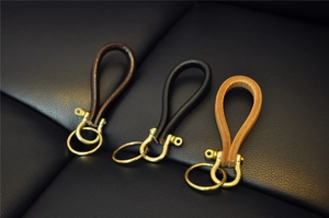 Detailed view of handmade leather keychains with vintage brass hooks in three colors