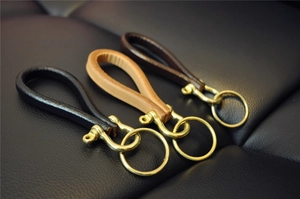 Three premium leather keychains with brass hardware in black, tan and dark brown colors