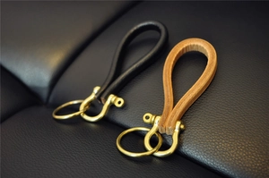 Detail of vintage brass horseshoe buckles with premium black and brown cowhide leather