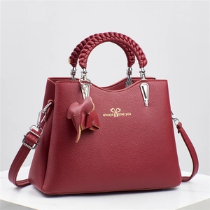 Red lychee pattern leather handbag with woven handle and elephant charm decoration