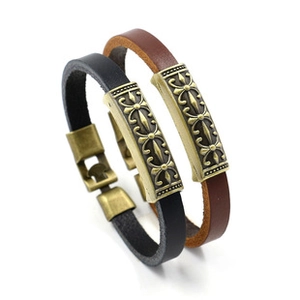 Detail of vintage punk leather bracelets in black and brown with ornate bronze skull metal studs