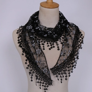 Detail of black lace triangle veil with white floral embroidery and bead tassels