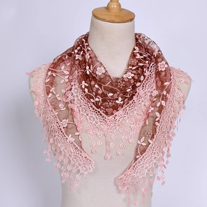 Detail of floral lace embroidery and delicate tassels on breathable triangle headscarf