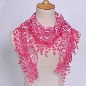 Detail of rose pink lace triangular shawl featuring floral embroidery and tassel fringe