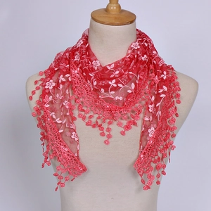 Detail of red floral lace embroidery on sheer mesh triangle scarf with pom-pom trim
