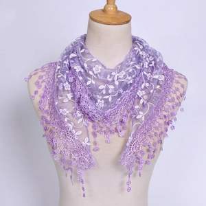 Detailed view of purple lace triangle scarf with white floral embroidery and tassel fringe