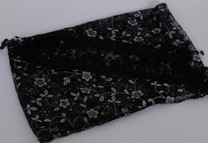 Detail of black floral lace triangle scarf with white embroidery and crochet edges