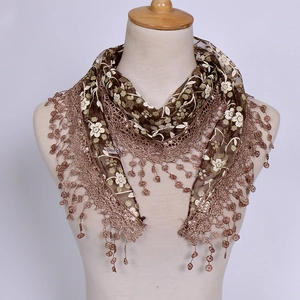 Detail of vintage brown triangle lace veil scarf with white floral embroidery and tassels