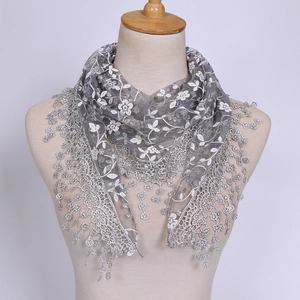 Close-up of grey lace triangle headscarf with white floral embroidery and scalloped fringe