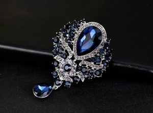 Macro shot of luxury vintage water-drop brooch with deep blue rhinestones and crystal pendants