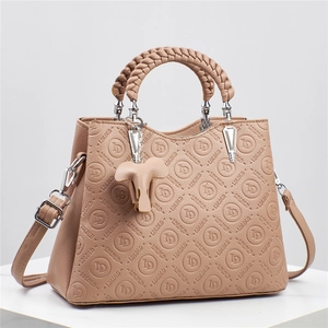 Bolso beige grabado con asa trenzada y colgante de elefante de cuero