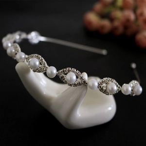 Detail of silver headband featuring elegant pearls and sparkling rhinestones on a hand stand