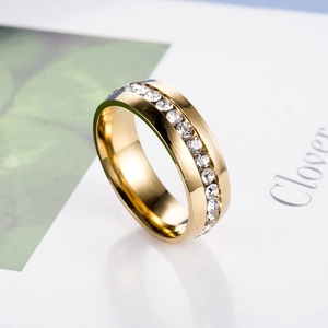 Close-up of golden brushed titanium steel ring with sparkling pavé-set zircons on surface