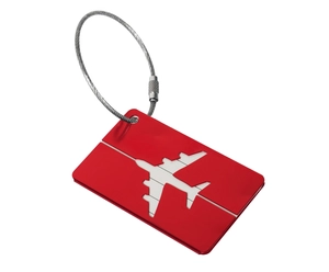 Detail of red aluminum luggage tag with airplane cutout and steel wire loop