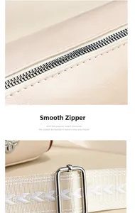 Makrodetail des glatten Reißverschlusses und verstellbaren Webriemens der beige Tasche