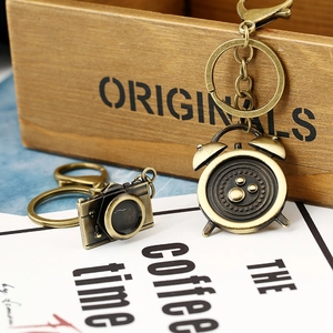 Detailed macro view of vintage bronze camera and alarm clock metal keychains