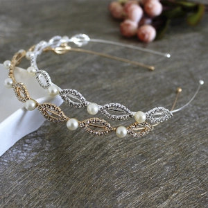 Elegant gold and silver hairbands with pearls and rhinestones on a textured surface