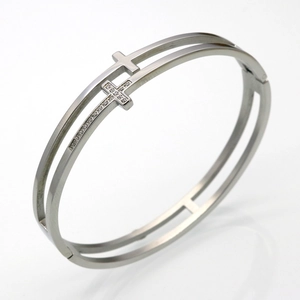 Detail of silver double-layered cross bracelet featuring pavé-set zircons on stainless steel