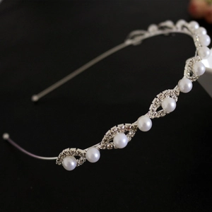 Elegant bridal headband featuring white pearls and leaf-shaped rhinestones on silver frame