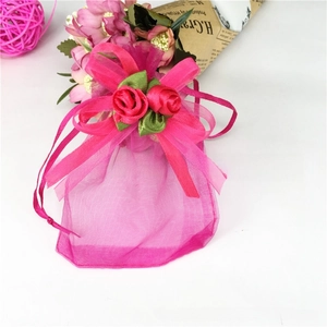 Rose pink organza gift pouch with decorative silk roses and drawstring closure detail
