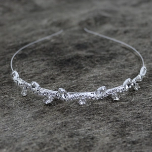 Elegant wide silver headband with sparkling crystal rhinestones on a textured grey background