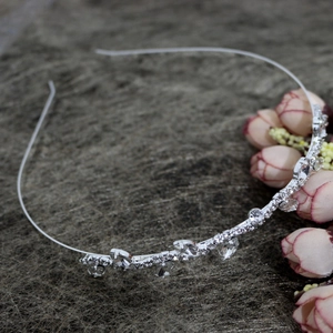 Elegant silver rhinestone headband with leaf ornaments on a dark textured background