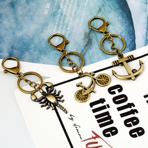 Vintage bronze metal keychains featuring scorpion, bicycle, and anchor designs in set