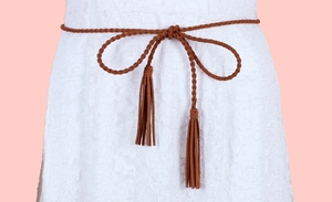 Detailed view of a brown braided waist rope with tassels on a white lace dress garment