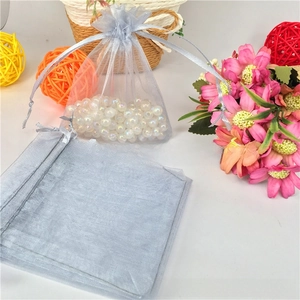Detail of silver organza drawstring bags showing sheer mesh texture and silk ribbon closure
