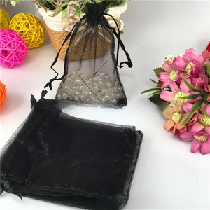 Detail of black organza drawstring gift bag showing sheer mesh texture and fill effect