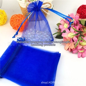Detailed view of blue organza drawstring gift bags with iridescent beads inside